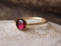 Garnet Gold Ring, Red Gemstone Stacking Ring, Dark Red Minimalist Ring, January Birthstone, Gold Filled Ring, Garnet jewelry, Red Stone Ring This red garnet gold stacking ring will be a perfect gift for women. It is made of 14k gold filled and garnet stone. Measurements: Size- all The center stone is 6 mm The ring will be packed in a gift box. FOR MY RINGS COLLECTION HERE: https://www.etsy.com/il-en/shop/rebekajewelry?section_id=14282915&ref=shopsection_leftnav_9 TO GET TO MY SHOP: https://w Red Garnet Round Band Jewelry, Red Gemstone Stackable Rings Fine Jewelry, Red Gemstone Stackable Rings In Fine Jewelry, Fine Jewelry Red Gemstone Stackable Rings, Red Ruby Birthstone Ring With Round Stone, Red Solitaire Ruby Ring As A Gift, Red Gemstone Stackable Rings For Formal Occasions, Red Birthstone Stackable Rings Fine Jewelry, Red Round Stone 14k Gold Jewelry