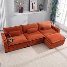 an orange sectional sofa in a living room with white walls and carpeting on the floor