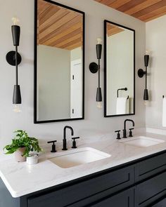 a bathroom with two sinks and mirrors on the wall