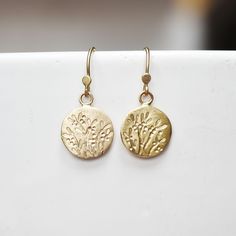 "Handmade 14k gold coin earrings with a hand drawn succulent pattern. Sweet coin earrings for every day wear. Simple and elegant for every occasion. Patterned coins - about 12mm's in diameter, each about 1.5grams of gold Earrings - About 5/8\"L Pattern - I hand draw the pattern using chasing tools making each pair one of a kind. *Non U.S. buyers - please read my shop policies for information regarding possible import taxes and fees before purchasing. Thanks for looking! Lilian" Gold Etched Round Earrings, Sterling Silver Etched Gold Earrings, Gold Etched Dangle Jewelry, Gold Etched Sterling Silver Earrings, Nature-inspired Yellow Gold Jewelry With Matching Earrings, Nature-inspired Yellow Gold Earrings For Gift, Gold Nature-inspired Earrings For Everyday, Nature-inspired Gold Earrings For Everyday, Yellow Gold Nature-inspired Drop Earrings