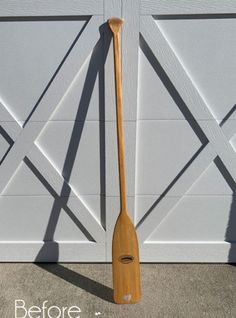 a wooden paddle leaning against a garage door