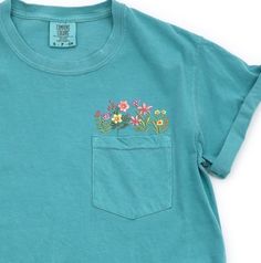 Comfort Colors Embroidered crewneck wildflower pocket tshirt. Embroidered flower shirt. Flower Boho Shirt. Gift for her or Girlfriend Gift. PLEASE NOTE THAT THE PICTURES ON THE LISTING ARE SAMPLES ONLY. If interested in adding embroidery to the sleeve please go to this listing: https://www.etsy.com/listing/1674502020 Because it is made to order, we don't accept the return or exchange unless we make a mistake We are unable to replace or refund purchases based on the color and the font selections. Wildflower Pocket Shirt Embroidered, Spring Green T-shirt With Embroidered Graphics, Summer Graphic Tee With Pockets, Spring Blue Tops With Side Pockets, Cute Spring Tops With Pockets, Green Pocket T-shirt For Spring, Green Spring T-shirt With Pockets, Spring T-shirt With Pockets And Relaxed Fit, Green T-shirt With Pockets For Spring