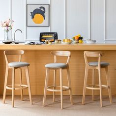 three wooden stools sit in front of a kitchen island with breakfast food on it