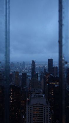 the city skyline is lit up at night, with skyscrapers visible in the distance