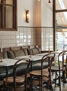 an empty restaurant with tables and chairs in front of large windows that look out onto the street