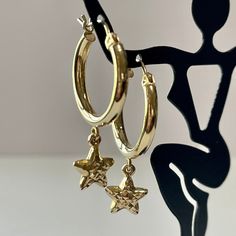 "14k yellow gold dangle star hoop earrings! This matching pair have a hanging dangling star design, and secure with lever back earring closures. These hoops are comfortably lightweight, and hollow by design, with the star having a pretty etched designs. A trendy pair of fine celestial earrings!  ERA - Circa 1990's METAL / MATERIAL - 14k yellow gold  MARKINGS / HISTORY - Earrings are marked \"14K\"SLC CONDITION - Good condition. Yellow gold metal has been polished & cleaned. Amazing modern earrings!  MEASUREMENTS - Earrings: 1 1/4 x 7/8 inches, Weight (both earrings): 1.86 grams" 14k Gold Hoop Earrings With Dangling Charms As Gift, Everyday Yellow Gold Earrings With Star Charm, Elegant Round Hoop Earrings With Star Charm, Gold Earrings With Star Charm In 14k Gold, 14k Yellow Gold Earrings With Dangling Charms, Celestial Style 14k Yellow Gold Hoop Earrings, Yellow Gold Hoop Earrings With Charms In 14k Gold, Adjustable Celestial Hoop Earrings, Elegant Dangle Hoop Earrings With Star Charm