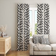 a living room with white walls and black and white curtains