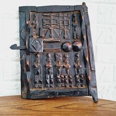 an old wooden door with carvings on the front and sides is sitting on a table