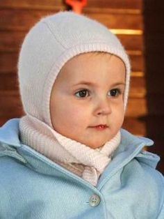 a small child wearing a blue coat and white hat