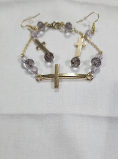 Purple beads set off the gold colored cross on this set. The bracelet is 7" Bracelet And Earring Set, Purple Beads, Rainbow Earrings, Cross Bracelet, The Gold, Red Heart, Green And Gold, Jewelry Set, Earring Set