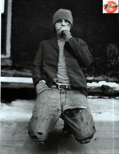 a young boy sitting on the ground with his mouth open while wearing a hat and tie