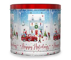 a red tin with a christmas scene on it and people around the house in the snow