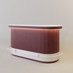 a red and white round object on top of a table next to a gray wall