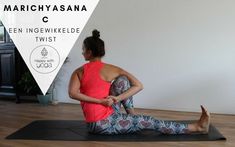 a woman sitting on a yoga mat with her legs crossed and arms behind her back