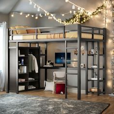 there is a loft bed with a desk underneath it and lights strung from the ceiling