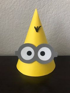 a yellow party hat with googly eyes on it