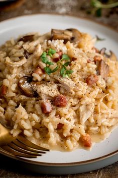 a close up of a plate of food with rice and mushrooms on it next to a fork