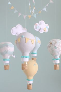 several hot air balloons hanging from strings in the shape of animals, clouds and kites