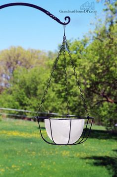 a hanging glass bowl in the middle of a grassy field