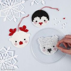 someone is making christmas ornaments out of bead and plastic beads on a white table