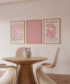 a dining room table and chairs with posters on the wall above it that say matissee picasso