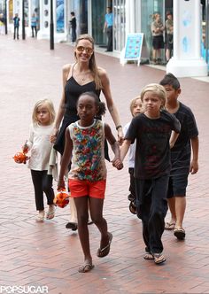 the woman is walking with her children down the street