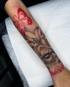 a woman's arm with a tattoo on it that has flowers and an eye