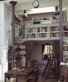 a living room filled with lots of books and furniture