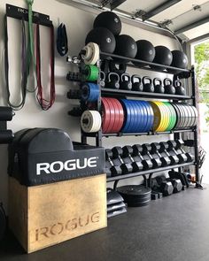 a room filled with lots of different colored dumbs and exercise equipment on display in front of a window