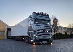 a large semi truck parked in front of a building