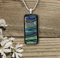 a glass pendant is sitting on a wooden table next to some flowers and white flowers