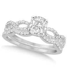 a white gold ring with an oval cut diamond in the center and two rows of round diamonds on each band