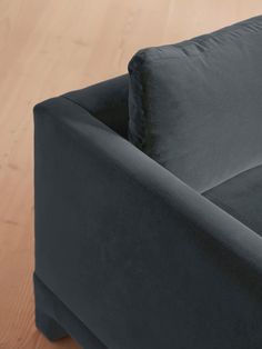 a black couch sitting on top of a wooden floor