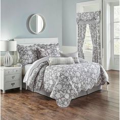 the comforter set is made up in grey and white floral print, with matching bedding