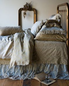 an old fashioned bed with two pillows on top of it and a book in the corner