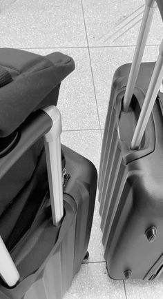 two pieces of luggage sitting on the ground next to each other, one black and white