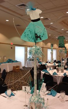 a room filled with tables covered in white and blue decorations