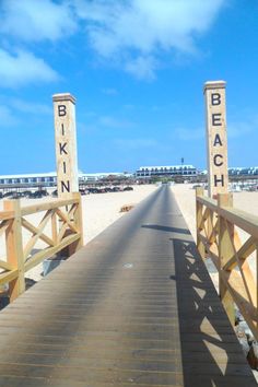 a wooden walkway leading to the beach with two signs that say blkn and n