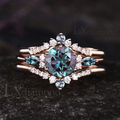 a ring with an aqua and white diamond surrounded by smaller blue diamonds on the side