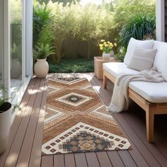 an outdoor area with wooden flooring and white couches, plants and potted trees