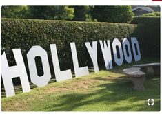 the hollywood sign is displayed in front of a hedged area with a picnic table and bench