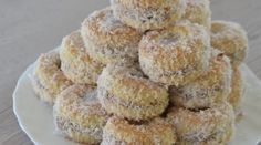 a pile of donuts sitting on top of a white plate covered in powdered sugar