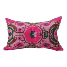 a pink and green decorative pillow on a white background with an ornate design in the middle