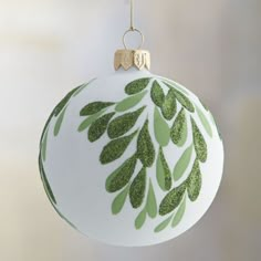 a white ornament with green leaves on it