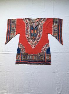 "1970s handmade pullover dashiki shirt soft cotton multi-color tapestry/batik style print main color-red wing sleeve 2 front hand pockets good vintage condition, light wear a few fabric worn spots (see photos) no size tag, see below measures, lying flat, neck to sleeve-15\" chest-19\" hem-22 1/2\" length-31 1/2\" length hits at upper thigh, more or less, depending on wearers height" Multicolor Cotton Long Sleeve Kaftan, Multicolor Long Sleeve Cotton Kaftan, Red Long Sleeve Casual Kaftan, Casual Red Long Sleeve Kaftan, Brown Cotton Long Sleeve Kaftan, Long Sleeve Brown Cotton Kaftan, Brown Long Sleeve Cotton Kaftan, Multicolor Bohemian Kaftan In Ankara Fabric, Handmade Pullover