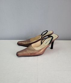 "Vintage golden bronze leather slip on shoes, glossy shoes with square toes. Mules with stiletto high heels. Women size EU 39. European Vergina footwear with elastic black gums on the surface.  No labeled materials. Brand: Vergina shoes  condition: Normal vintage, used, great surface with some slight signs of wear. Some signs of wear on the heels back.  measurements: Heels height 3.8\" in / 9,8 cm outside sole length from tip of toe to heel:  11.5\" in / 29,5 cm  outside sole bottom width in wid Clogs And Mules, Square Toe Heels, Leather Slip On Shoes, Black Gums, Clogs Shoes, High Heels Stilettos, Leather Slip Ons, Womens High Heels, On Shoes