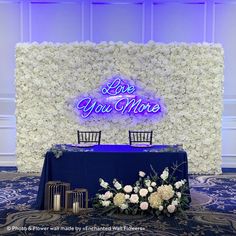 a blue table with white flowers on it and a sign that says love you more