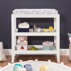 a baby's room with toys on the floor, and a toy shelf in the corner