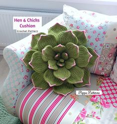 a green flower sitting on top of pillows