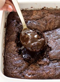 a person is spooning chocolate cake into a casserole dish with brownies in it